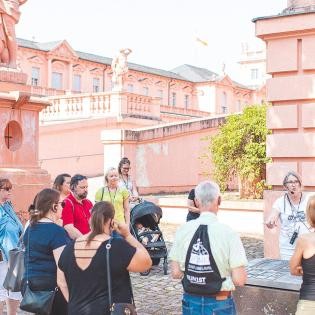 Touristengruppe bei einer Führung vor dem Schloss Rastatt