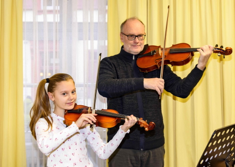 young girl and music teacher play the violin