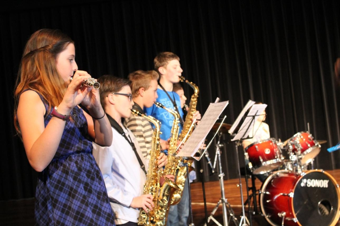 Pupils from the music school on a stage playing a piece together