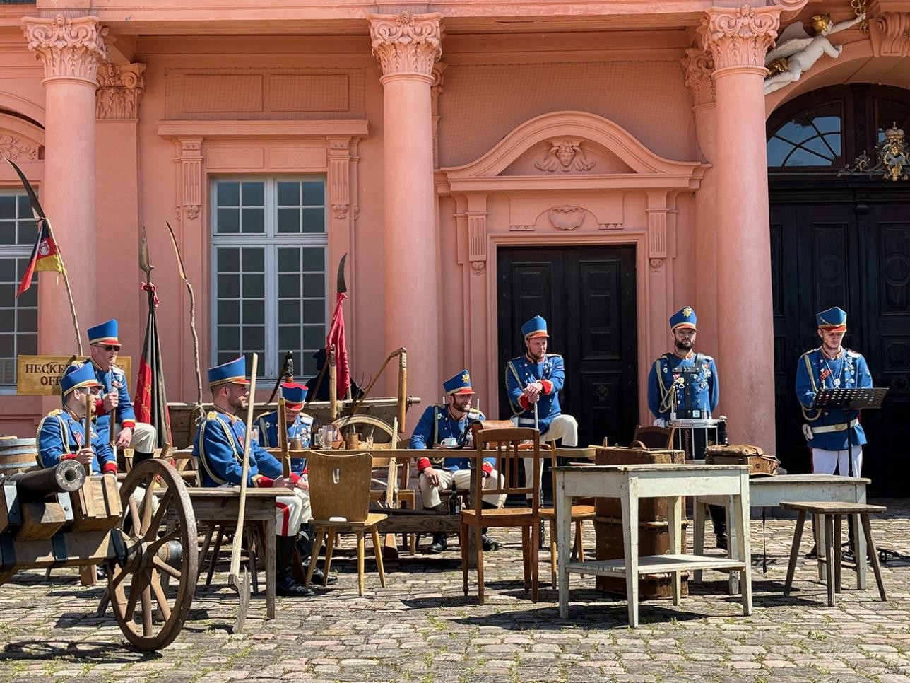 Soldaten sitzen vor dem Schloss beim Schauspiel "Zeitreise in die Badische Revolution 1849"