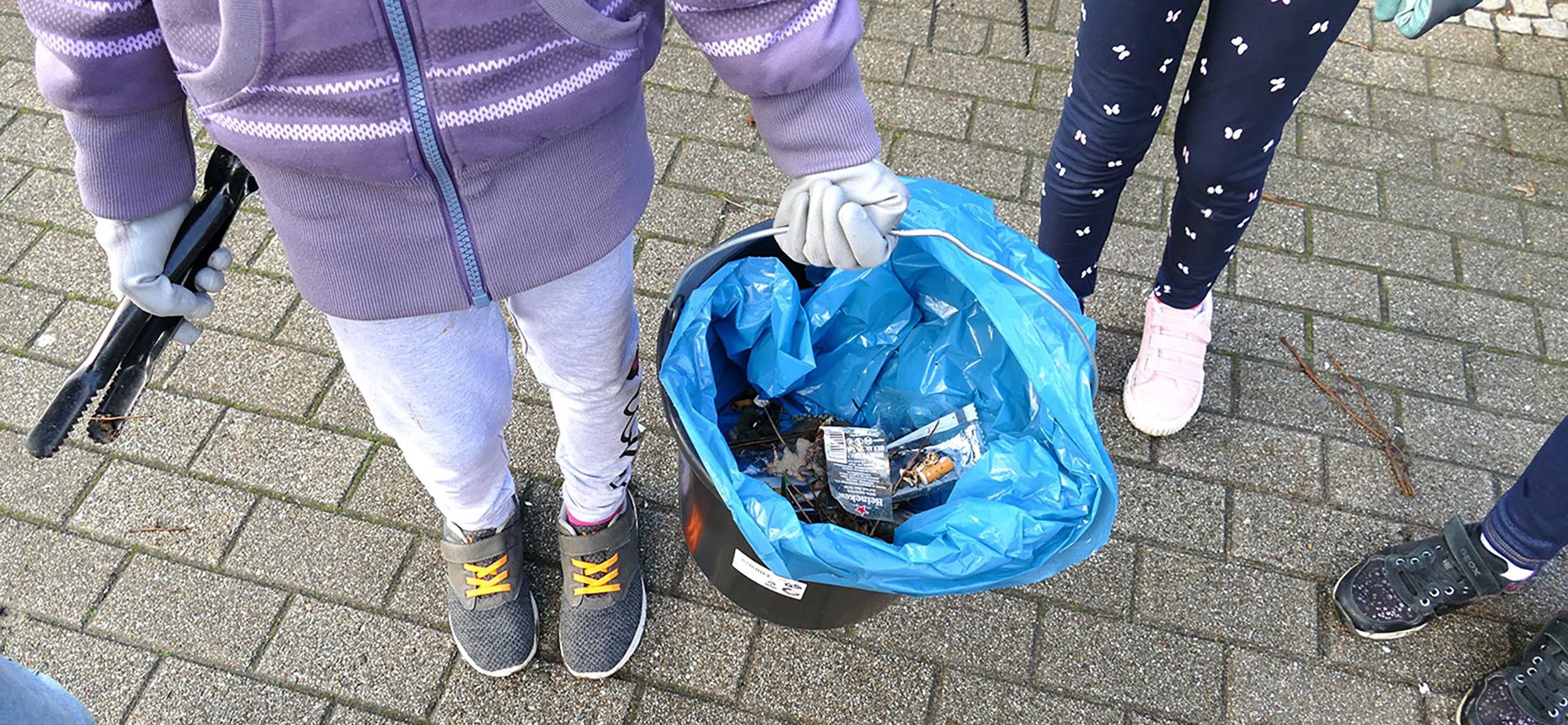 Mädchen hält Abfalleimer in der Hand