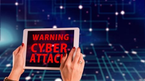 Une femme tient un plateau sur lequel est inscrit Warning Cyber Attack