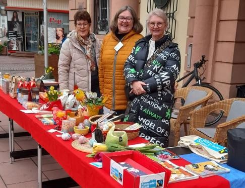 Frauen vor einem Tisch, die Fairtrade-Produkte verkaufen
