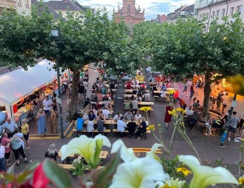Marktplatz mit Biertischen und Menschen