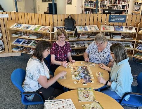 Menschen sitzen am Tisch und spielen