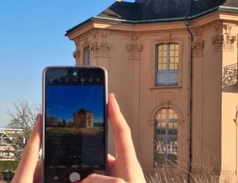 Zweimal ist die Pagodenburg zu sehen, als Fotomotiv auf dem Handy und das Gebäude im Hintergrund
