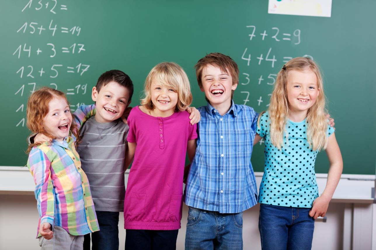 5 Kinder vor einer Tafel mit Matheaufgaben