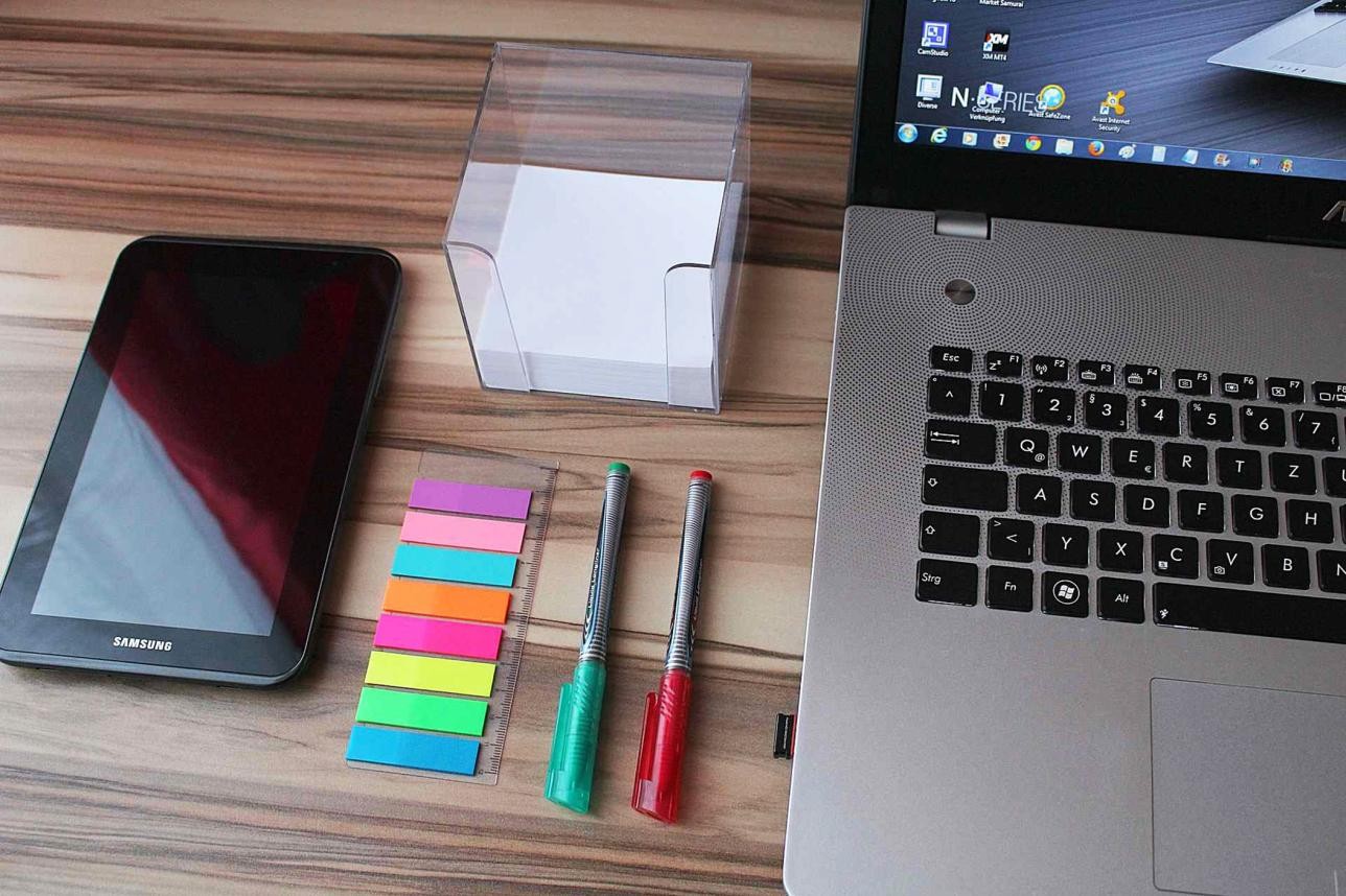 Tablet, Laptop und Büromaterial auf einem Tisch