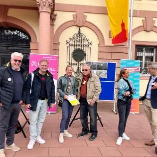 Photo de groupe au stand d'information sur la votation citoyenne devant l'hôtel de ville historique