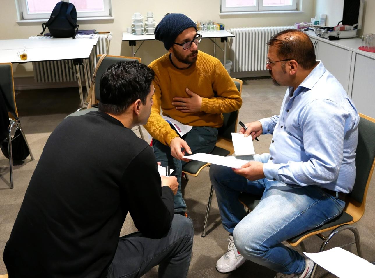 Trois hommes en discussion lors de la table ronde sur le dialogue