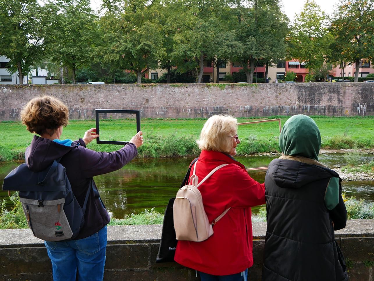 Three women stand by the Murg