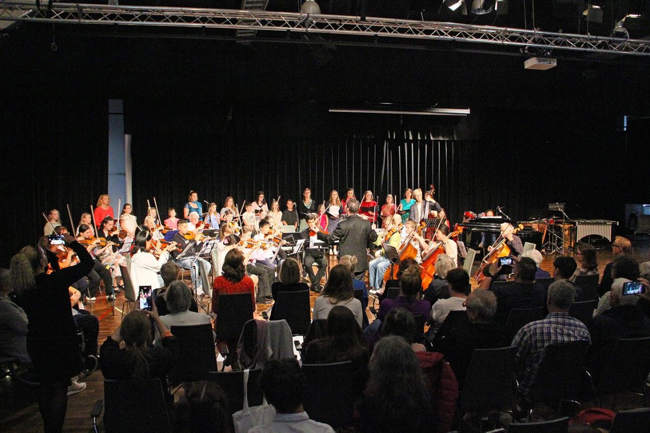Le public et les musiciens sur scène lors du concert familial de l'école de musique