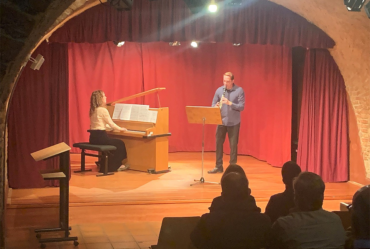 L'homme joue de la clarinette et est accompagné au piano dans le théâtre de la cave