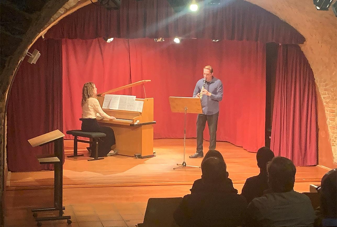 Man plays clarinet and is accompanied on the piano in the Kellertheater