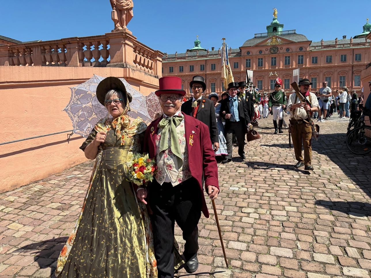 Actors run out of the courtyard towards the riding hall