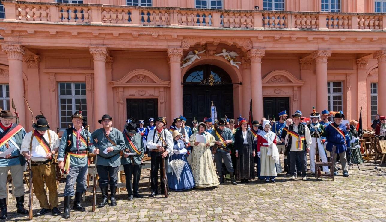 Menschen in historischen Kostümen im Schlosshof