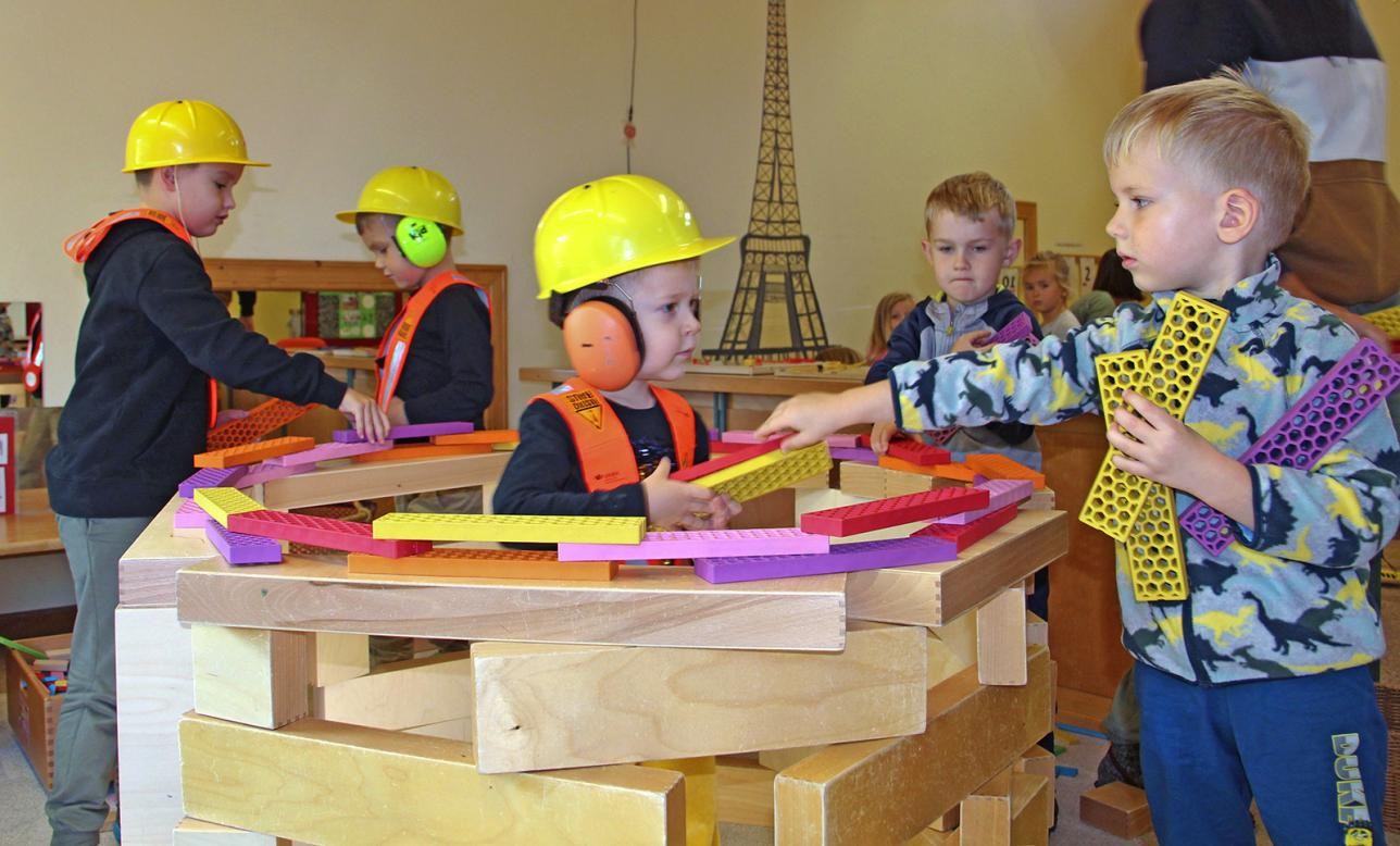 Kinder bauen ein Haus aus großen Bauklötzen