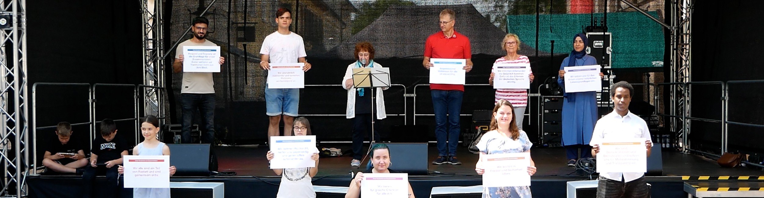 Lesung "Unser Verständnis vom Zusammenleben" auf dem Stadtfest 2025 auf Deutsch und Badisch. Foto: Stadt Rastatt Menschen stehen auf der Bühne beim MarktplatZ
