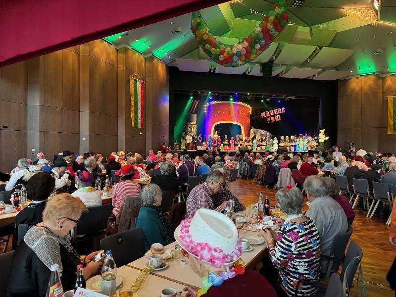 Senioren sitzen an Tischen beim Seniorenfasching