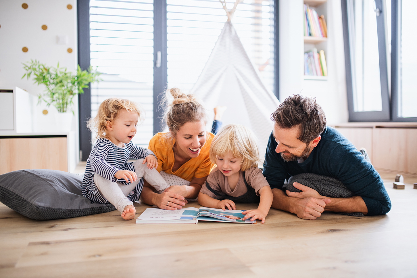 Parents read a book to children