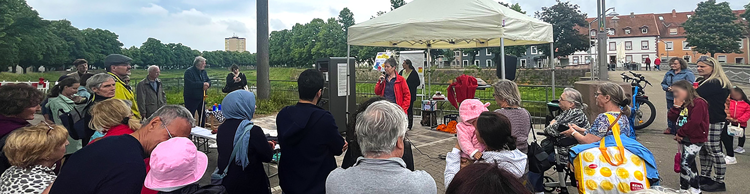 People stand by the river Murg at the opening of the open bookcase