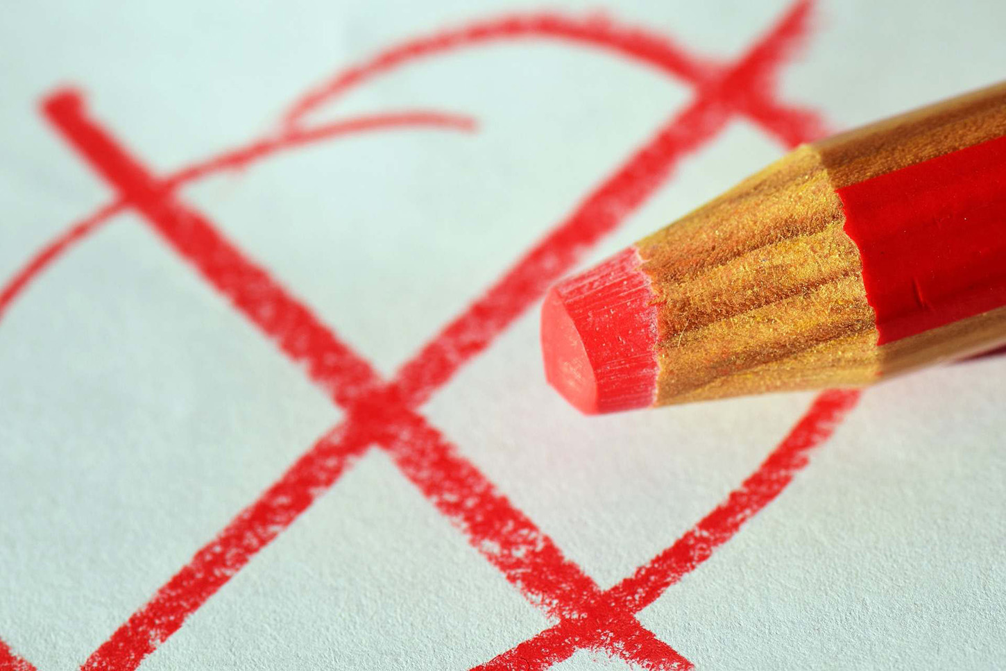 Red cross and a red pen. Symbolic image elections